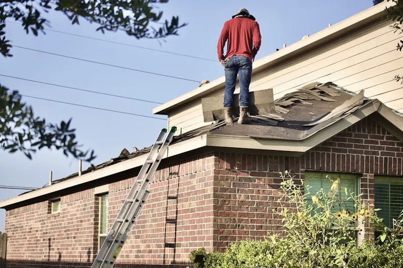 Professional roofer working on a residential roof in Windham Park